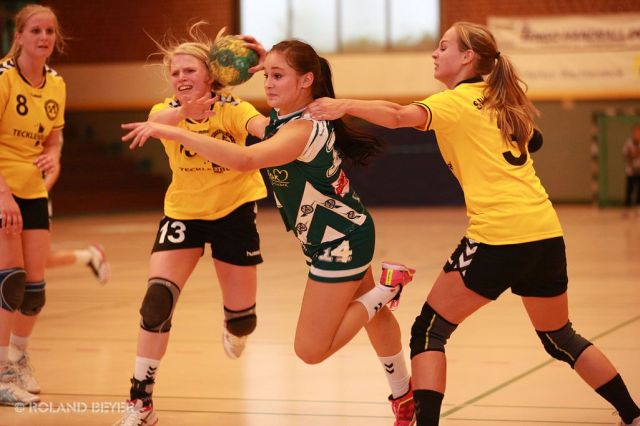 Eine junge Handballerin setzt sich gegen zwei Abwehrspielerinnen durch