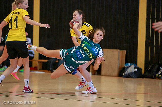 Eine junge Handballerin setzt sich gegen zwei Abwehrspielerinnen durch