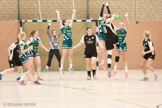 Mehrere Handballerinnen springen hoch, um einen gegnerischen Wurf zu blocken