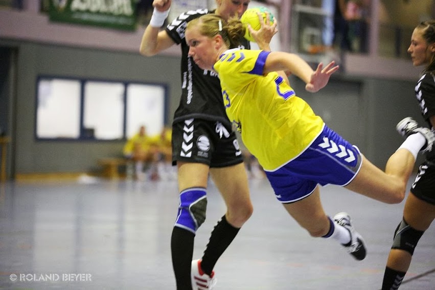 Ein junge Handballerin setzt sich gegen zwei Gegenspielerinnen durch