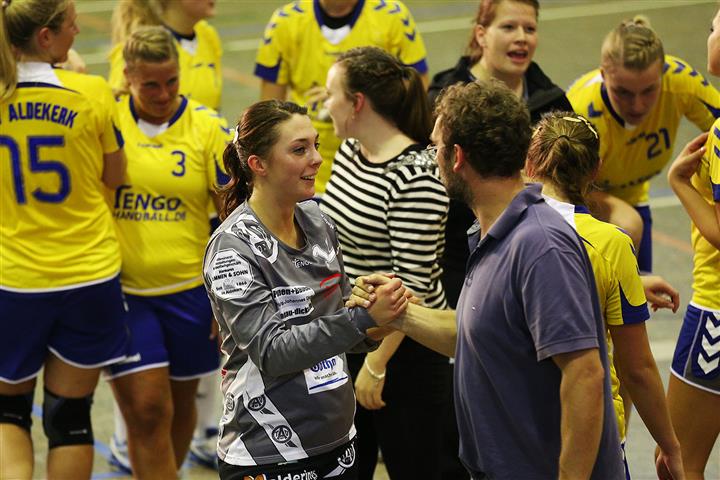 Ein Handballtrainer gratuliert seiner Spielerin nach dem Sieg 