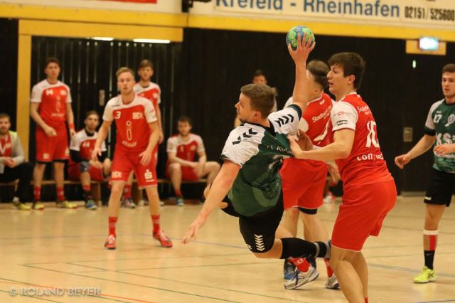 Ein Handballer der 1.Männer des TV Aldekerk setzt sich am Kreis gegen zwei Gegenspieler durch.