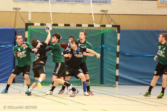 Eine Handball-Abwehrreihe blockiert einen Angreifer 