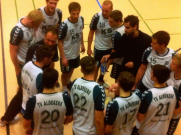 Ein Männer-Handballmannschaft steht im Kreis zusammen