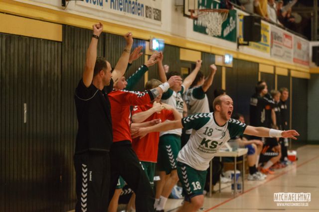 Die Auswechselbank einer Handballmannschaft springt nach dem Schlusspfiff jubelnd auf