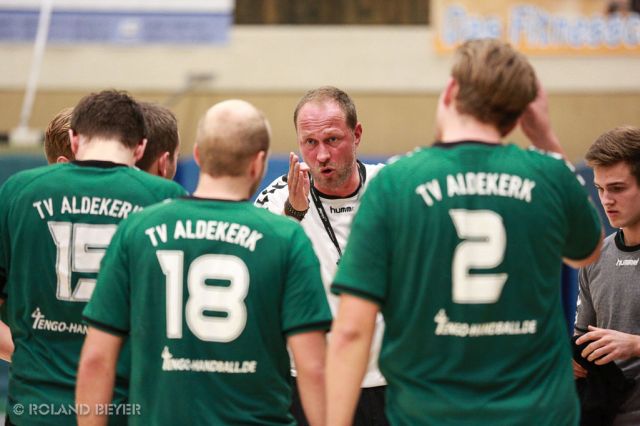 Ein Handballtrainer redet während einer Auszeit mit seiner Mannschaft