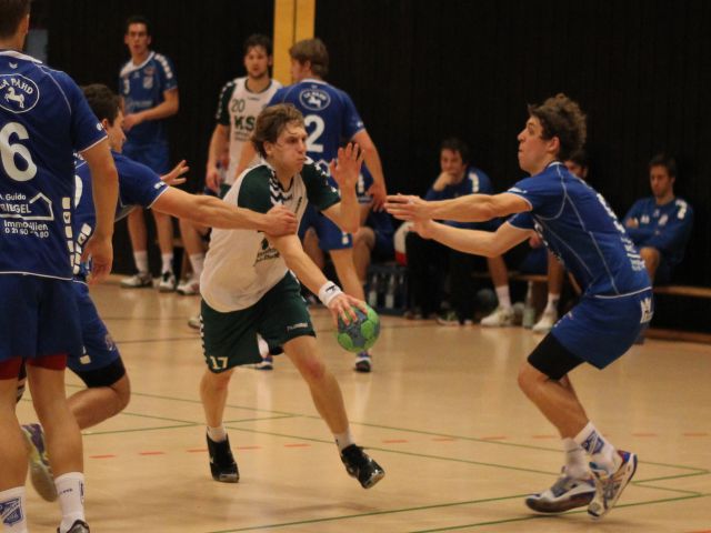 Ein Handballer setzt sich gegen zwei Gegenspieler durch
