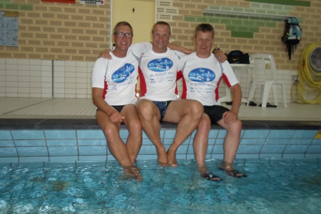 Drei Schwimmer des TV Aldekerk sitzen am Beckenrand im Hallenbad