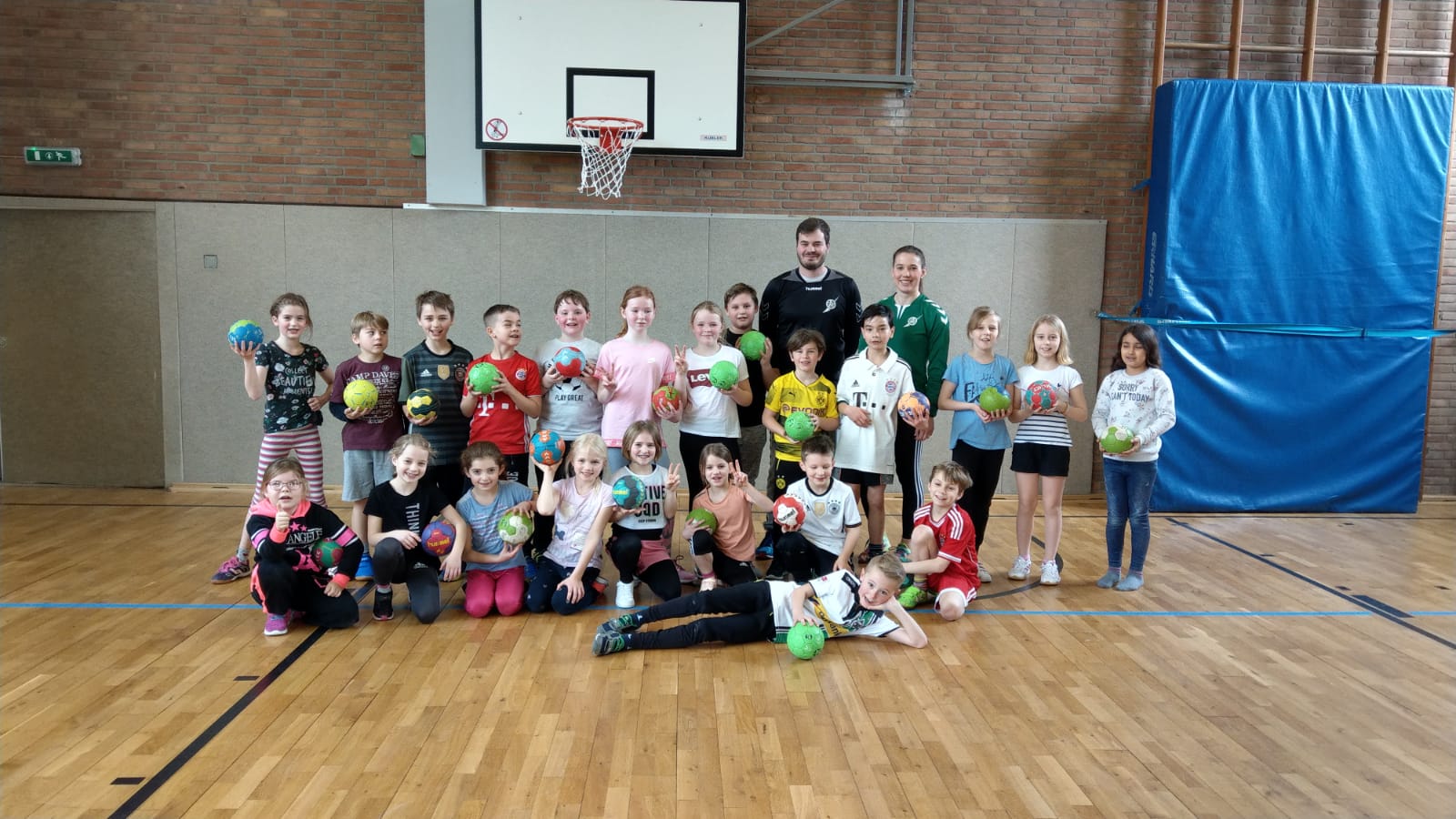 Kinder der Grundschule Rheurdt präsentieren sich zusammen mit Handballtrainer des TV Aldekerk